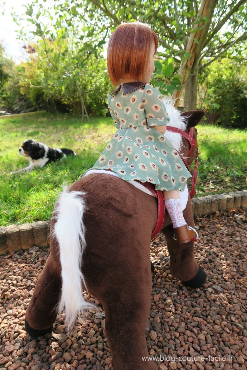 poupee sur son cheval vue de dos