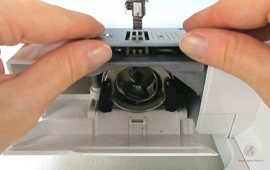 Dévisser la plaque à aiguille de la machine à coudre